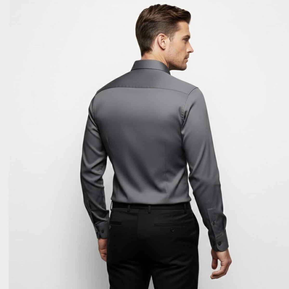 Back view of a man in a Kouvr Fashion dark grey slim fit dress shirt, highlighting the back yoke and tapered cut. 