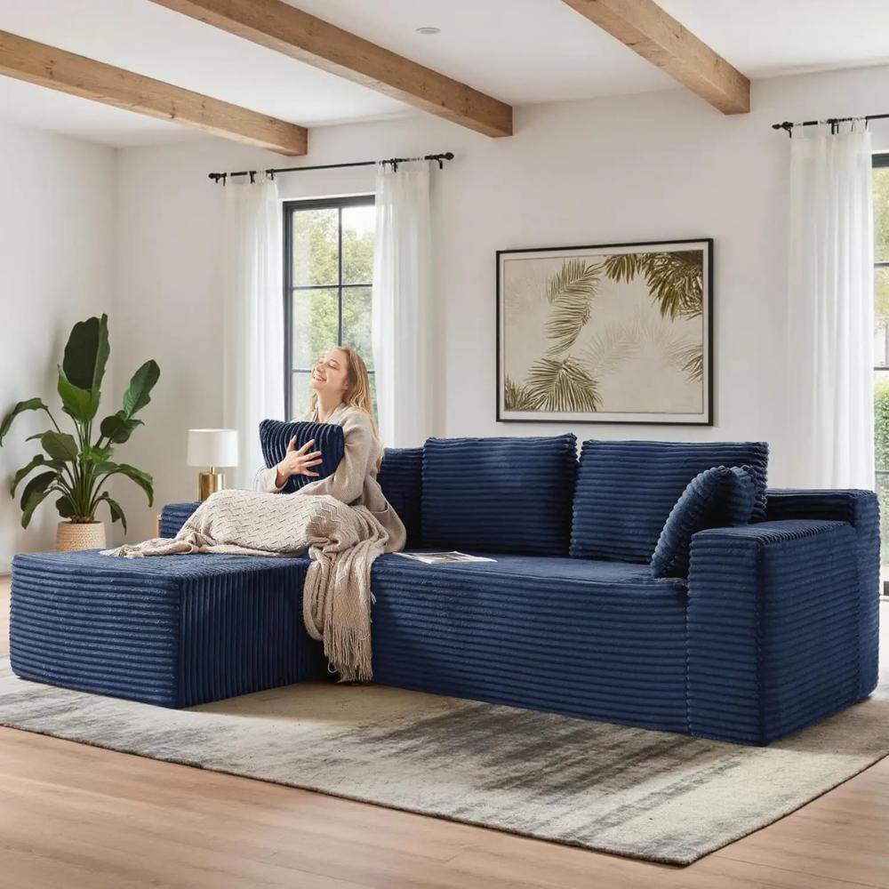 Woman relaxing on the Kouvr corduroy l-shaped cloud sofa in a modern grey living room