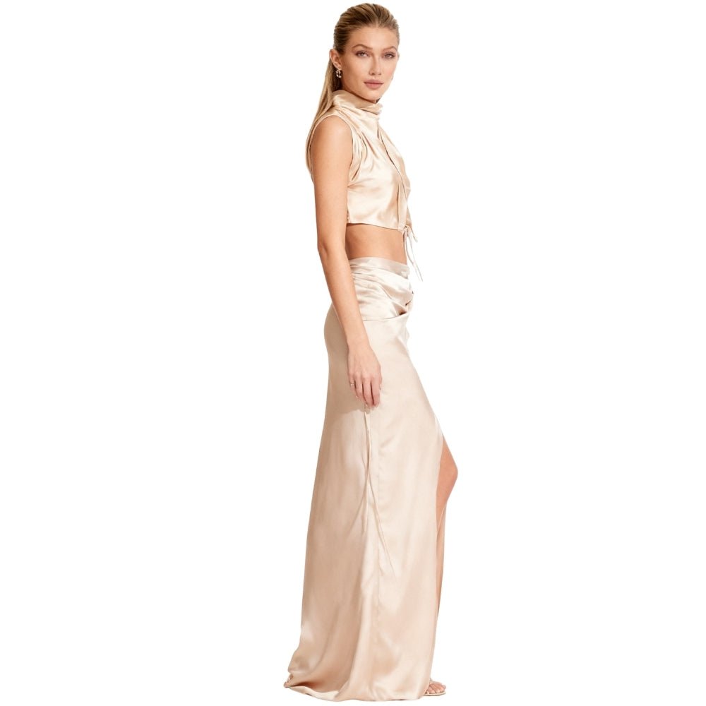 Woman wearing a cream Kouvr  satin two-piece outfit on a white background