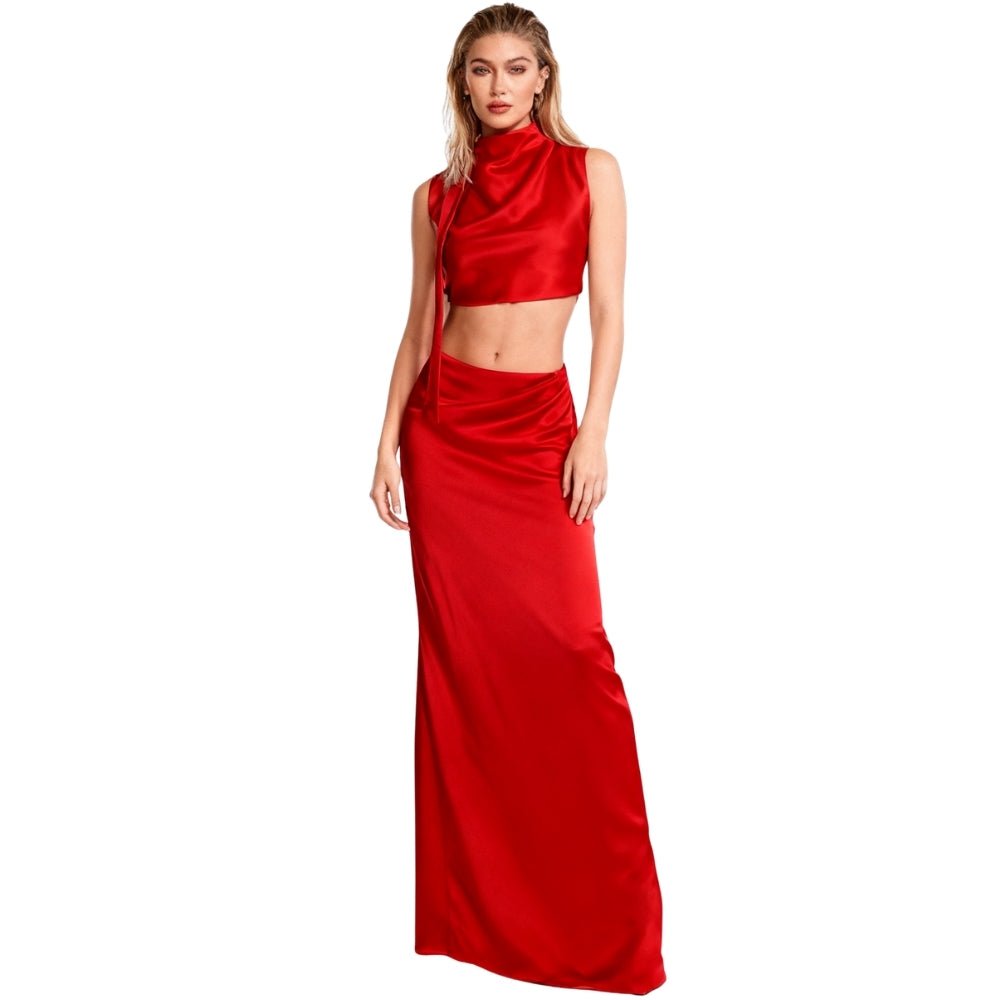 Woman wearing a red Kouvr satin two-piece outfit on a white background