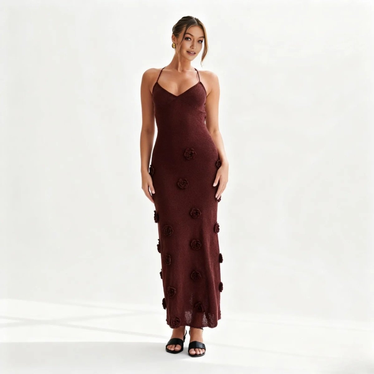 Woman wearing a burgundy dress with floral embellishments on a white background