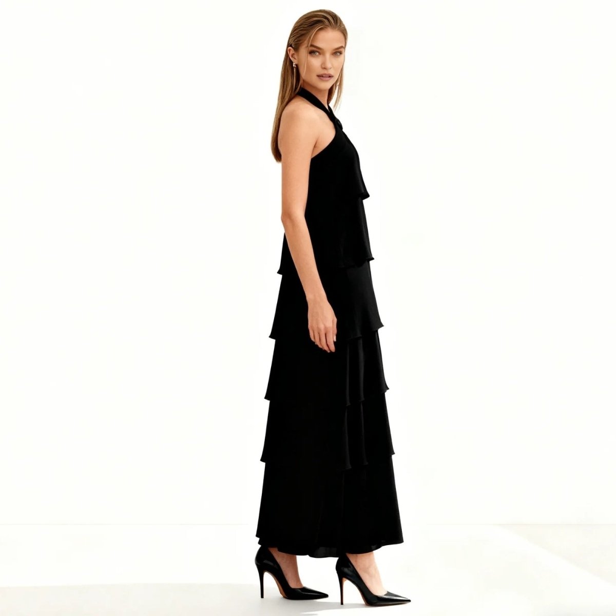 Woman wearing a black Kouvr tiered dress on a white background