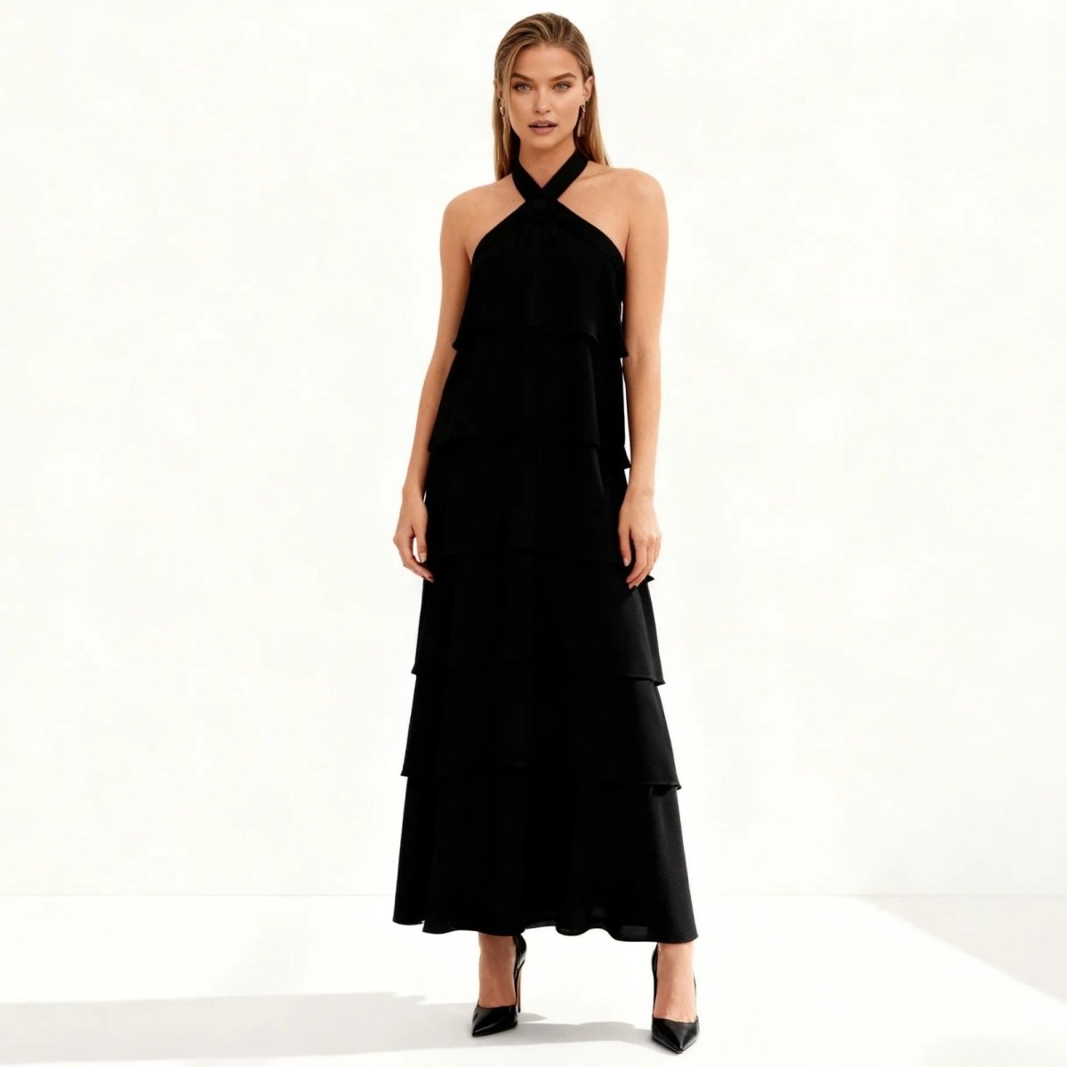 Woman wearing a black Kouvr halter neck dress on a white background