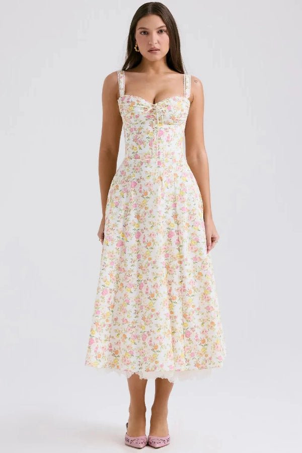 Model wearing Kouvr Fashion Eviva floral corset midi dress in white with pink and yellow flowers, showing the lace-up bustier and A-line skirt