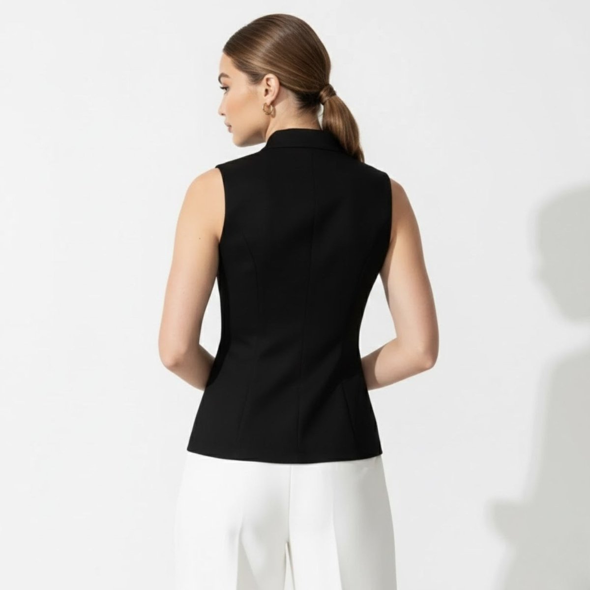 Back view of a model wearing the Kouvr Fashion black formal vest, showing the princess seam details. 