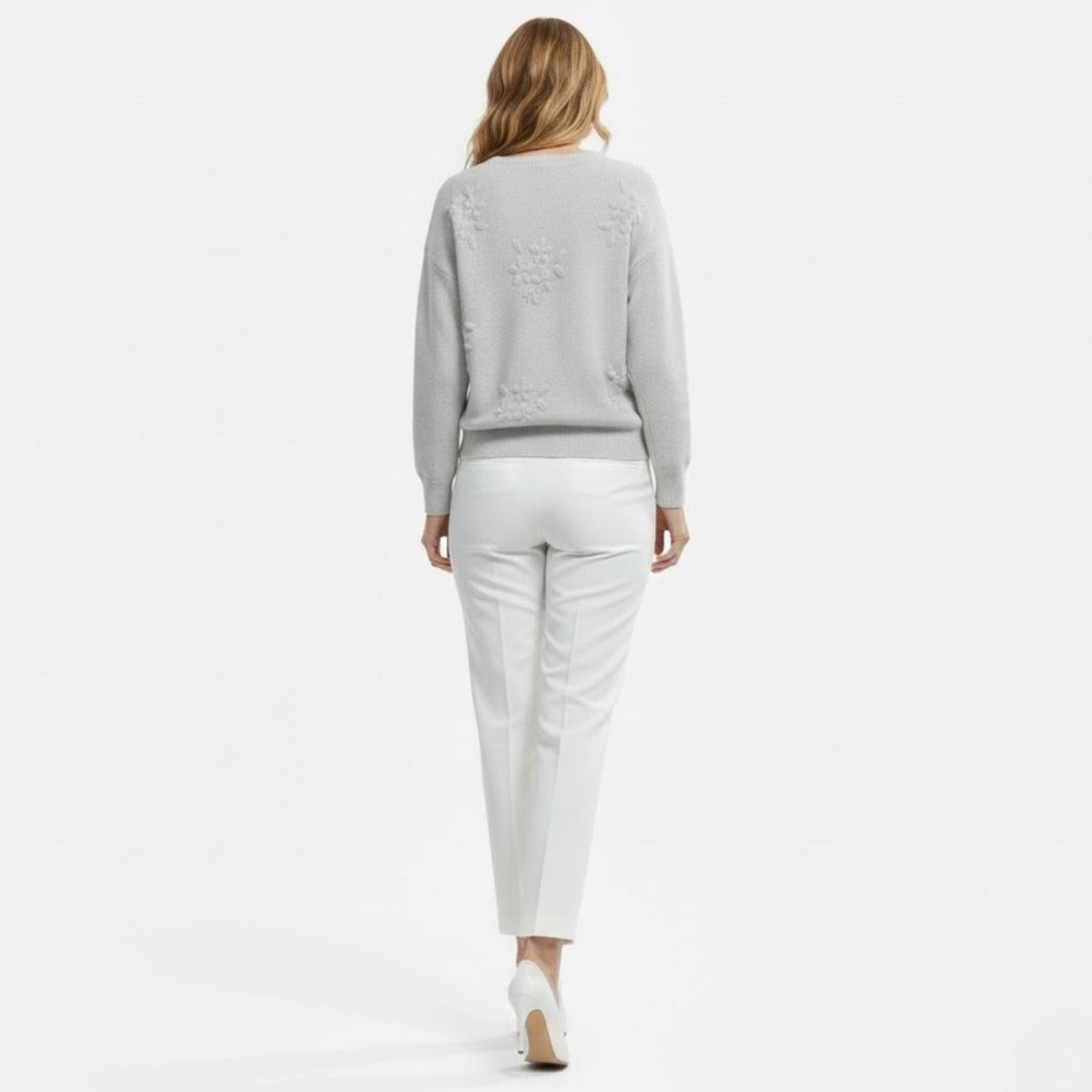 Model from the back, showcasing the floral appliqué details on the shoulders of the grey Fleur Sweater.
