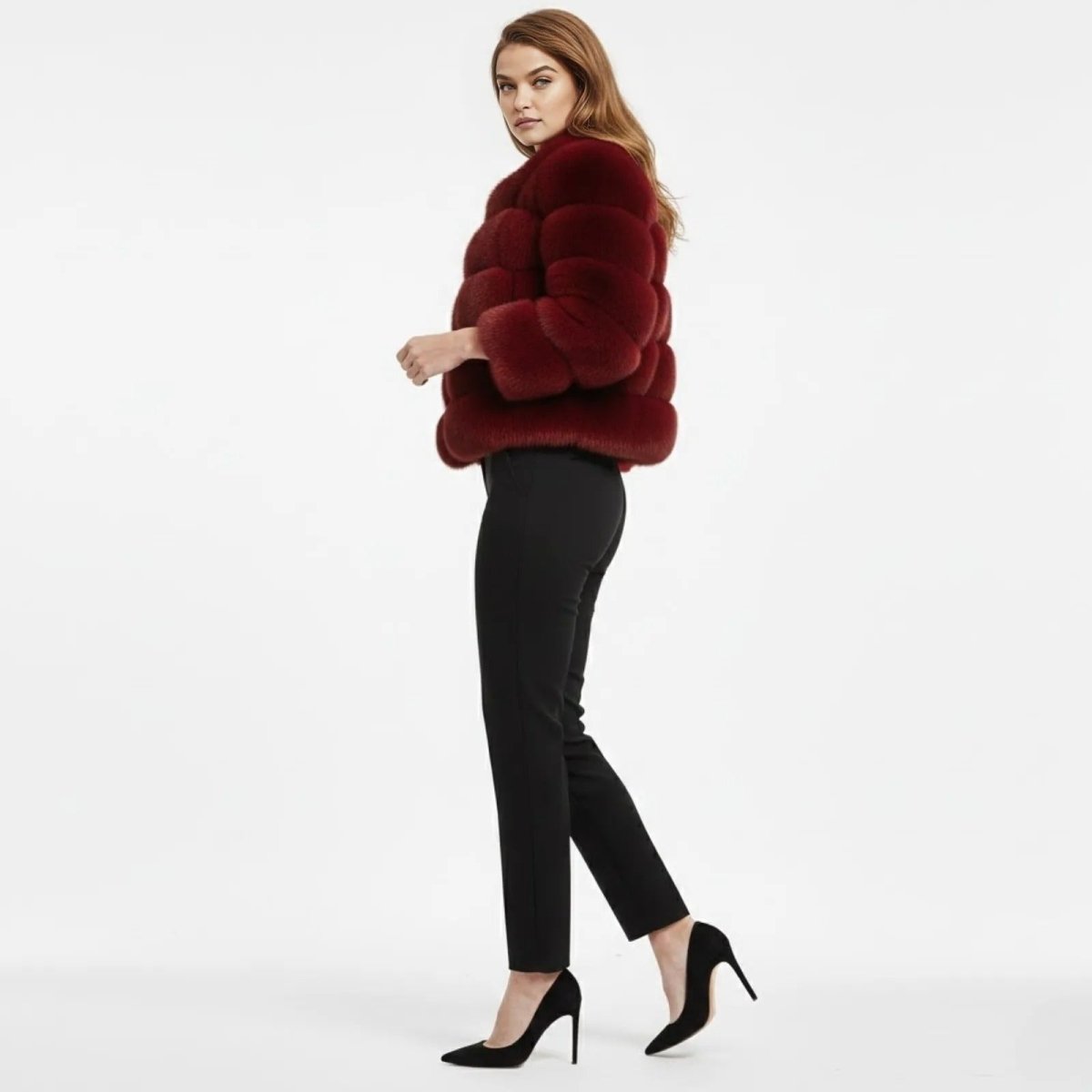 Side profile of a model walking in a luxury red faux fur winter coat with a high collar, showing the texture and cropped length.
