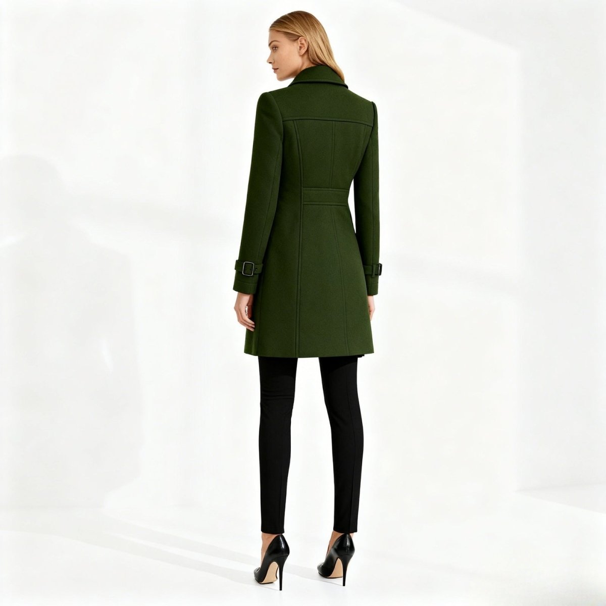 Woman wearing a green Kouvr coat on a white background