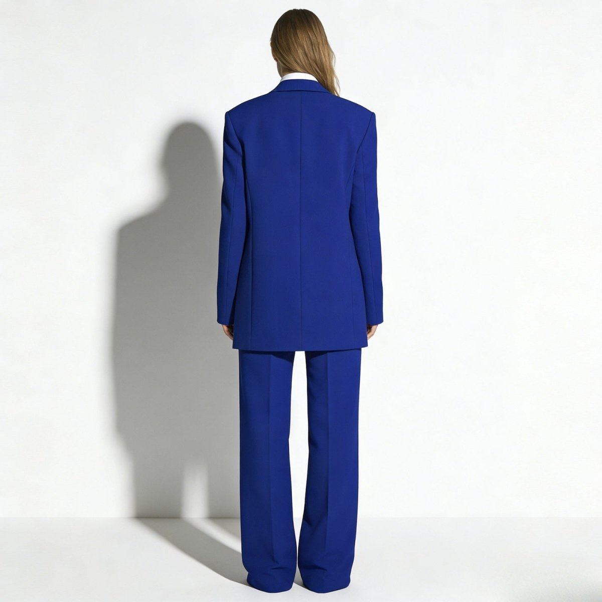 Back view of the Kouvr Fashion women's blue tailored suit, showcasing the clean lines and expert construction of the oversized blazer and trousers. 