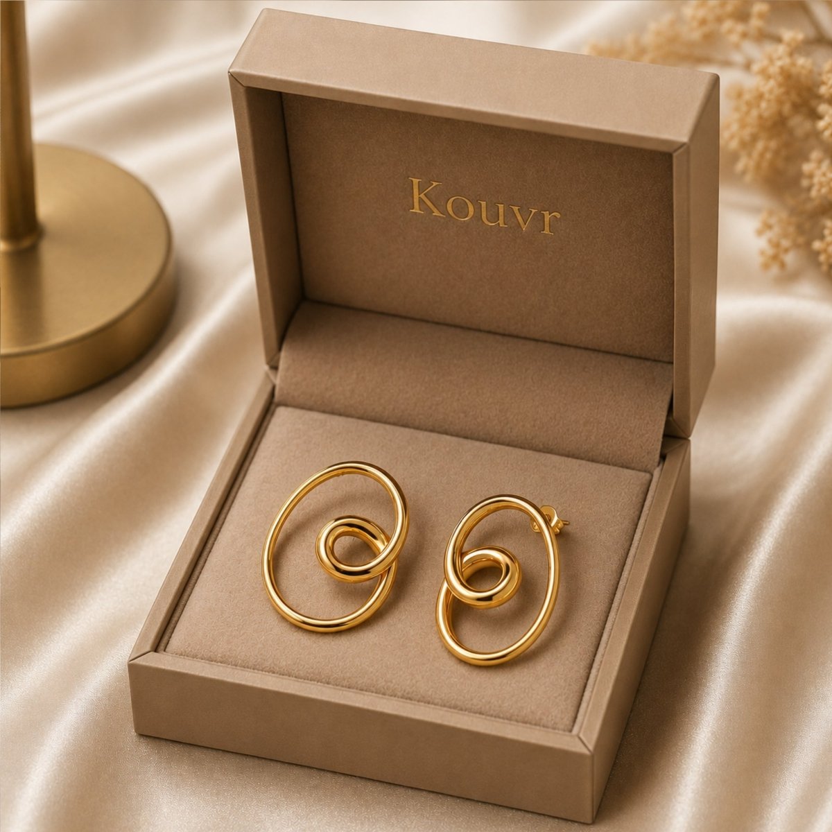 Gold finish sterling silver intertwined loop knot stud earrings elegantly displayed inside a beige Kouvr fine jewelry gift box.