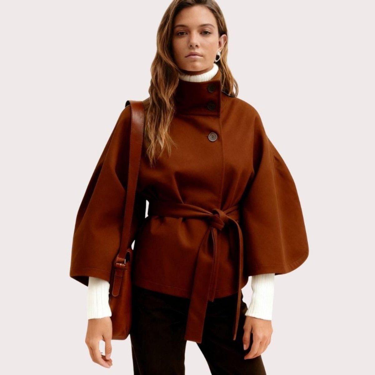 Model wearing Kouvr Fashion belted cape jacket with funnel neck and wide kimono sleeves