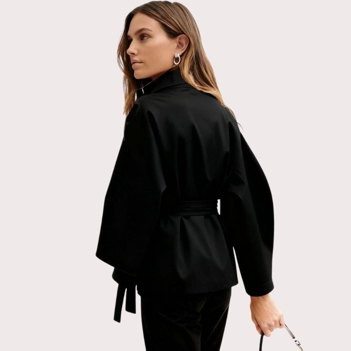 Model wearing Kouvr Fashion belted cape jacket with funnel neck and wide kimono sleeves