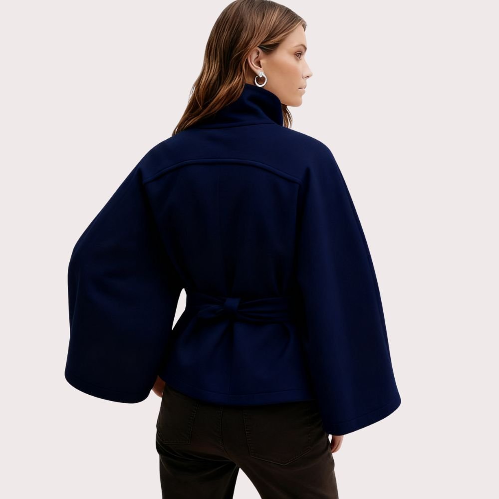 Model wearing Kouvr Fashion belted cape jacket with funnel neck and wide kimono sleeves