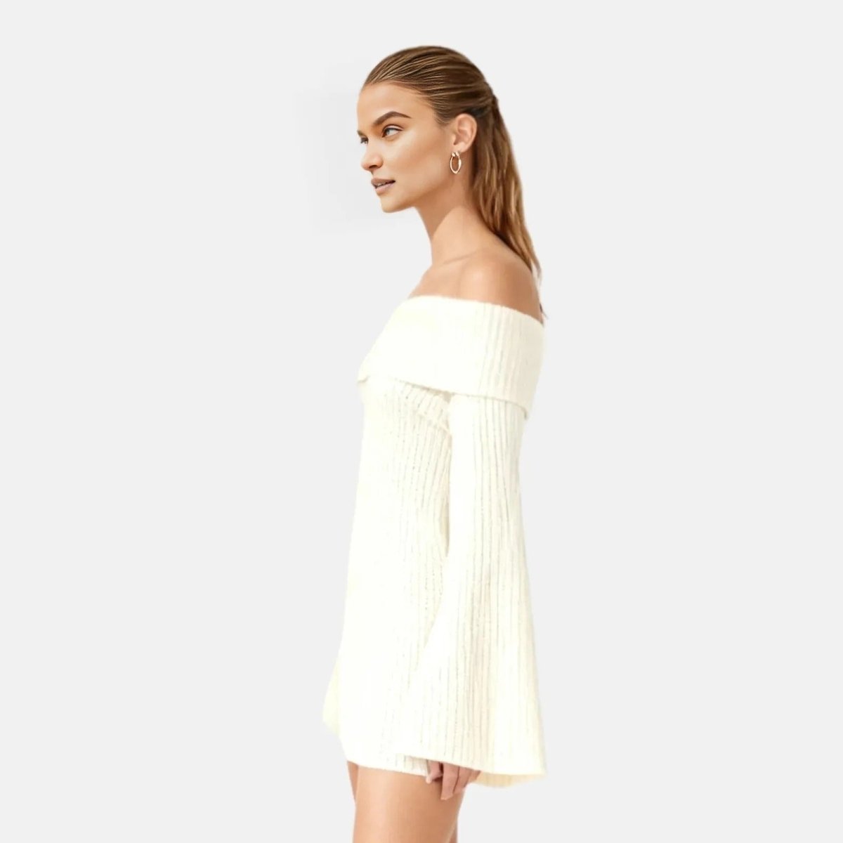 Woman wearing a ivory off-shoulder dress on a light gray background