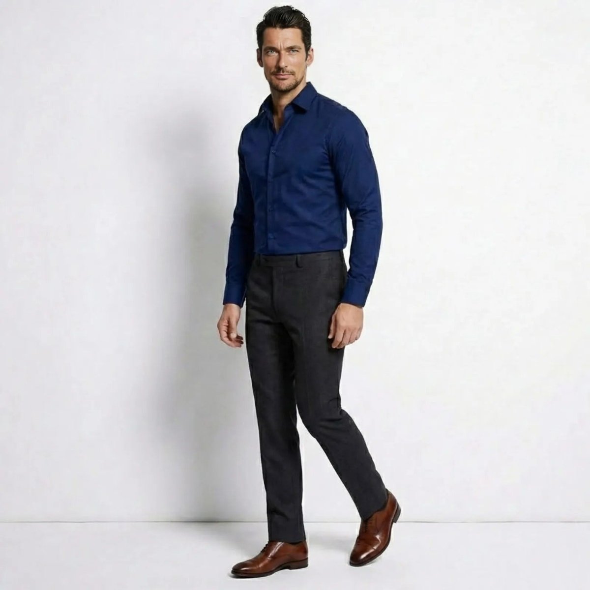 Side profile of a man in a Kouvr blue stretch cotton business casual shirt, showing its slim fit silhouette.
