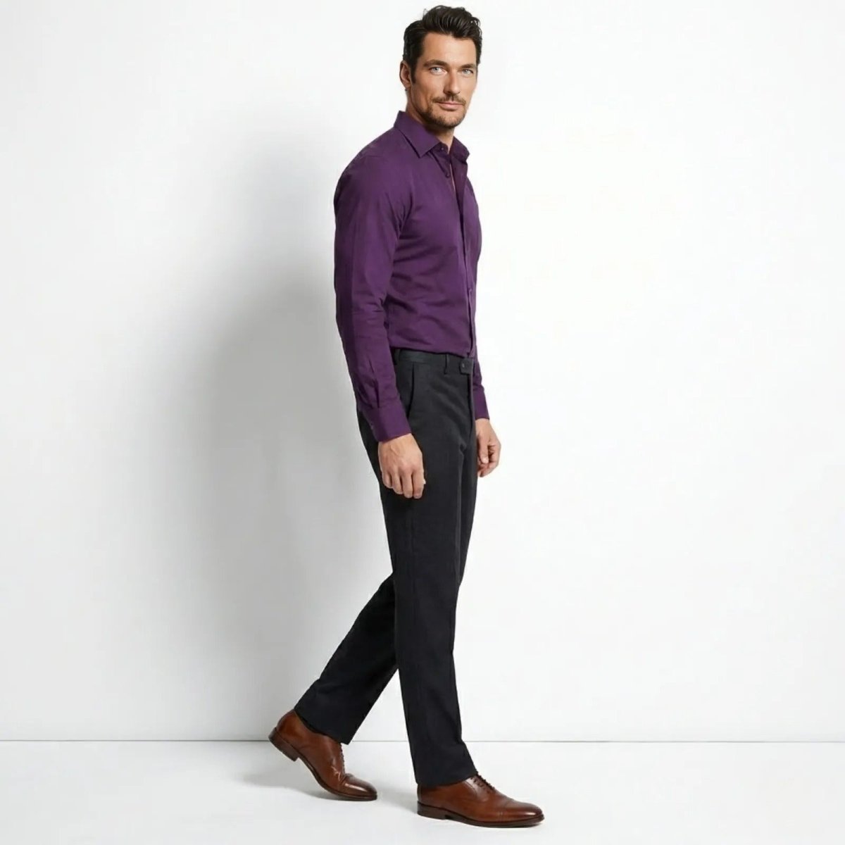 Male model in a side profile view walking, showcasing the slim fit of the Kouvr Leland purple button-down shirt.
