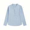 Flat lay of the Kouvr light blue linen Roby shirt, detailing the band collar, mother-of-pearl buttons, and fabric texture.
