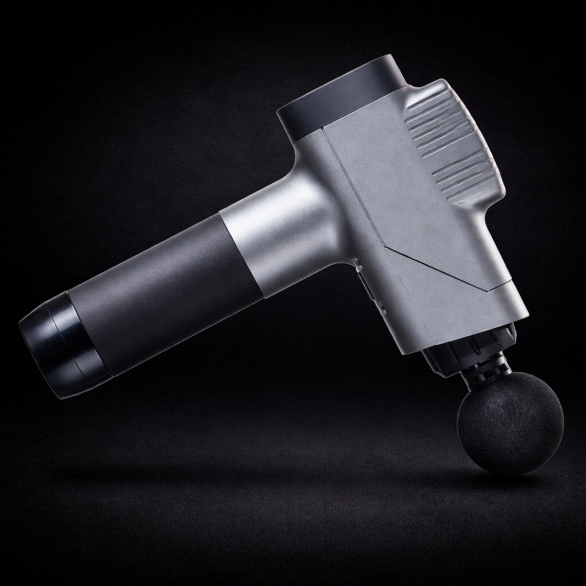  Angled downward view of the Kouvr massage gun showcasing the rounded massage head attachment