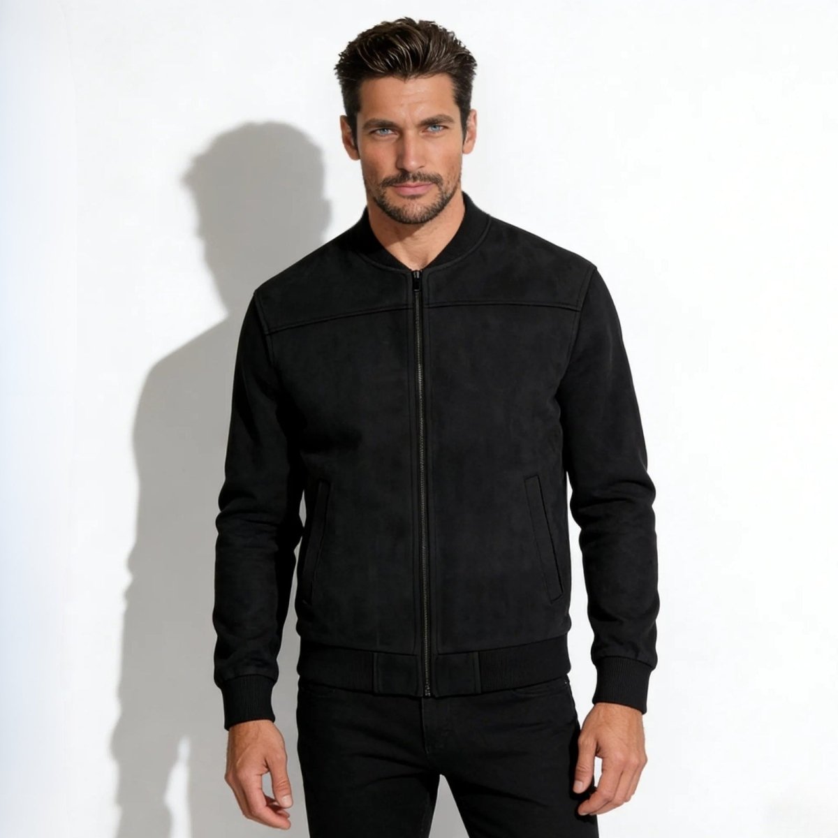 Model wearing the Kouvr men's black suede bomber jacket, viewed from the front against a white background.
