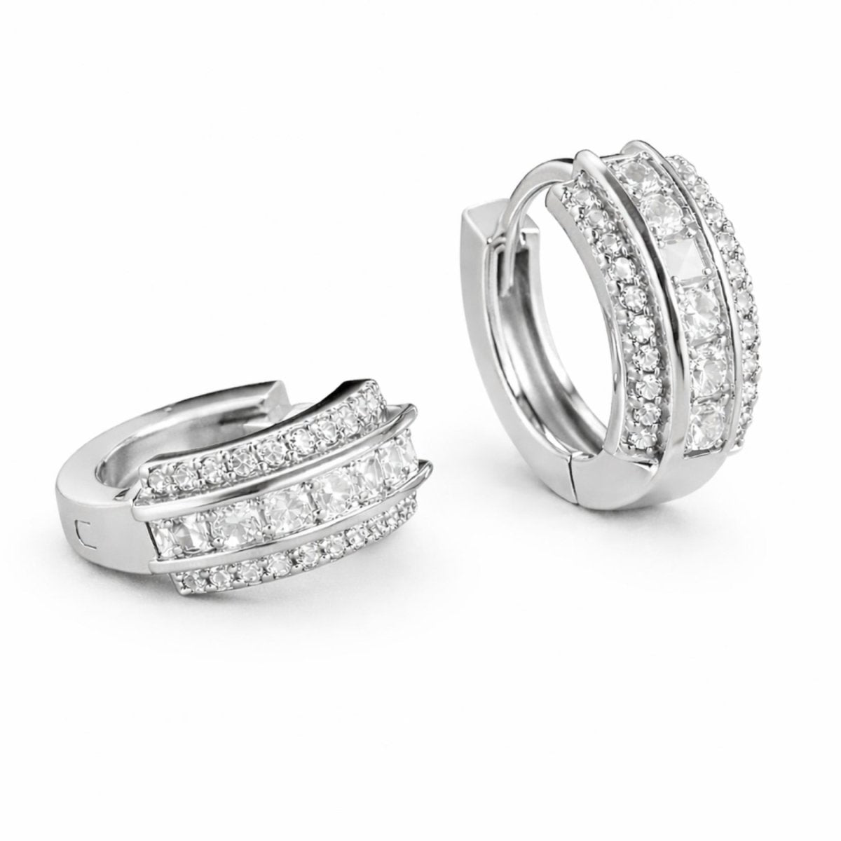  A pair of Kouvr princess cut diamond huggie hoop earrings in sterling silver on a clean white background, showing the side profile and front view.