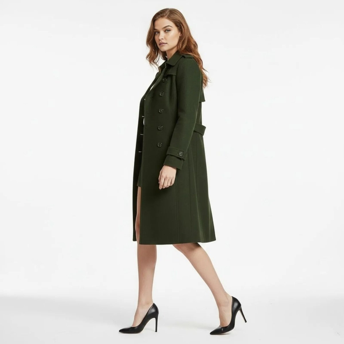 Side profile of a model walking in the Kouvr Rachelle army green wool trench coat, showing its length and movement.
