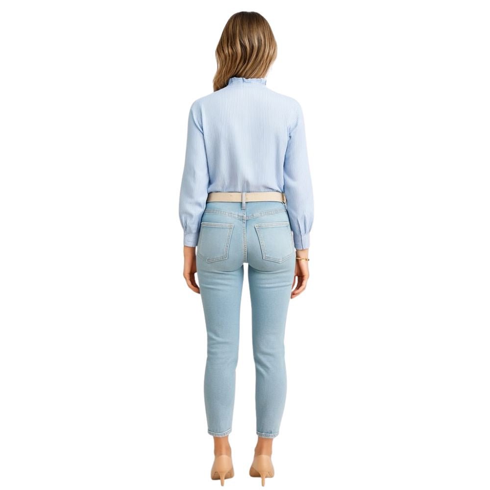 Model wearing the Kouvr Fashion Ruffle Neck Blouse, tucked into high-waisted light-wash jeans