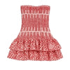 Model wearing the Kouvr red strapless mini dress with a smocked bodice and tiered ruffle skirt