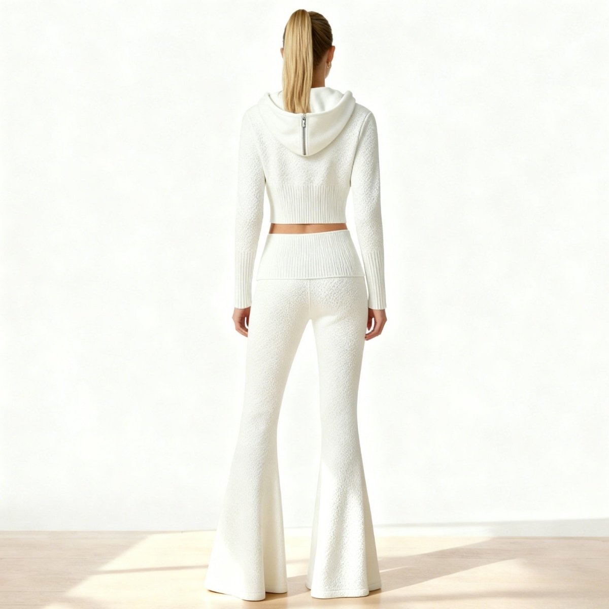 Back view of the Kouvr Stella&nbsp;two-piece set in white, showcasing the textured jacquard knit and the fit of the hoodie and flared pants.