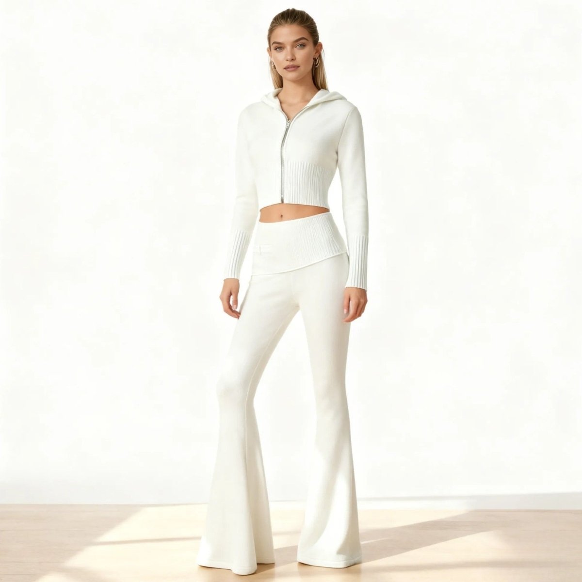 Model wearing the white Stella&nbsp;knit set by Kouvr Fashion, a two-piece outfit with a cropped zip hoodie and high-waisted flared pants.