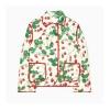 Front flat lay of the Kouvr strawberry quilted jacket, showing the collar, patch pockets, and red piping detail.