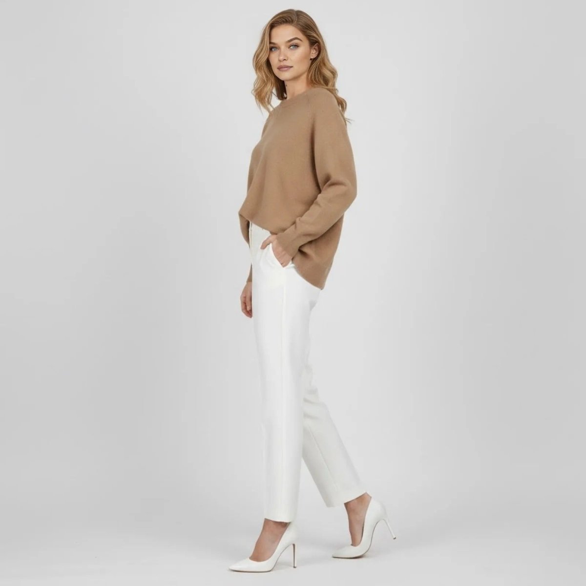 Side profile of a model in a light brown oversized sweater showing the slouchy fit and batwing sleeve detail.
