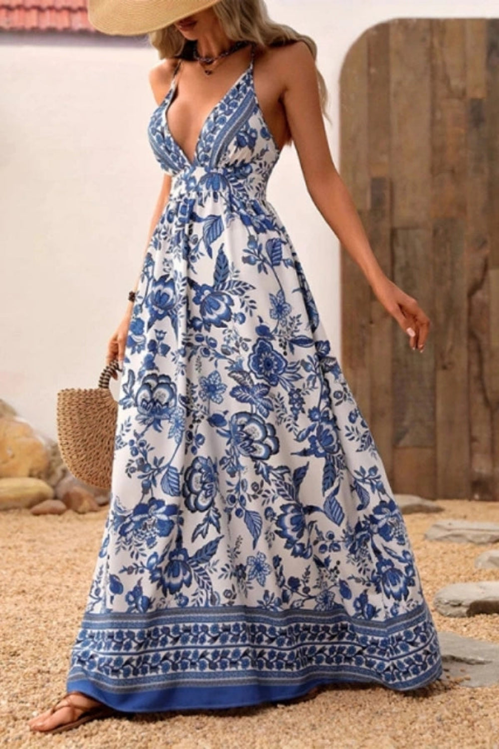 Woman walking in Kouvr Vanessa backless floral maxi dress showing criss-cross straps