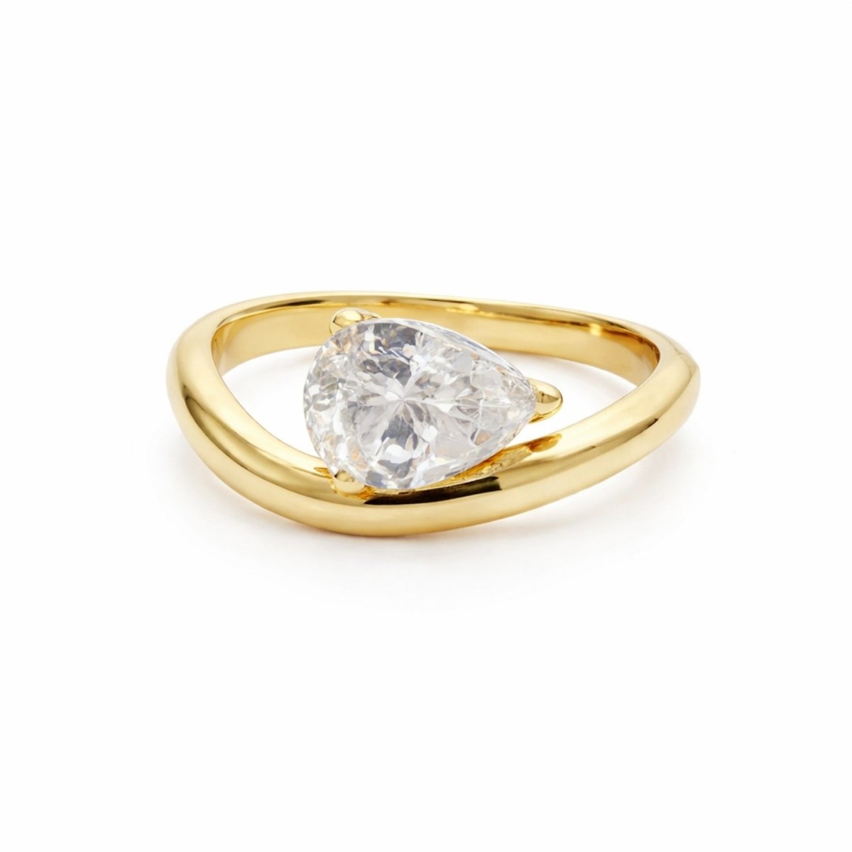 The Kouvr Zella gold bypass bangle bracelet with a single pear cut solitaire stone on a white background. 
