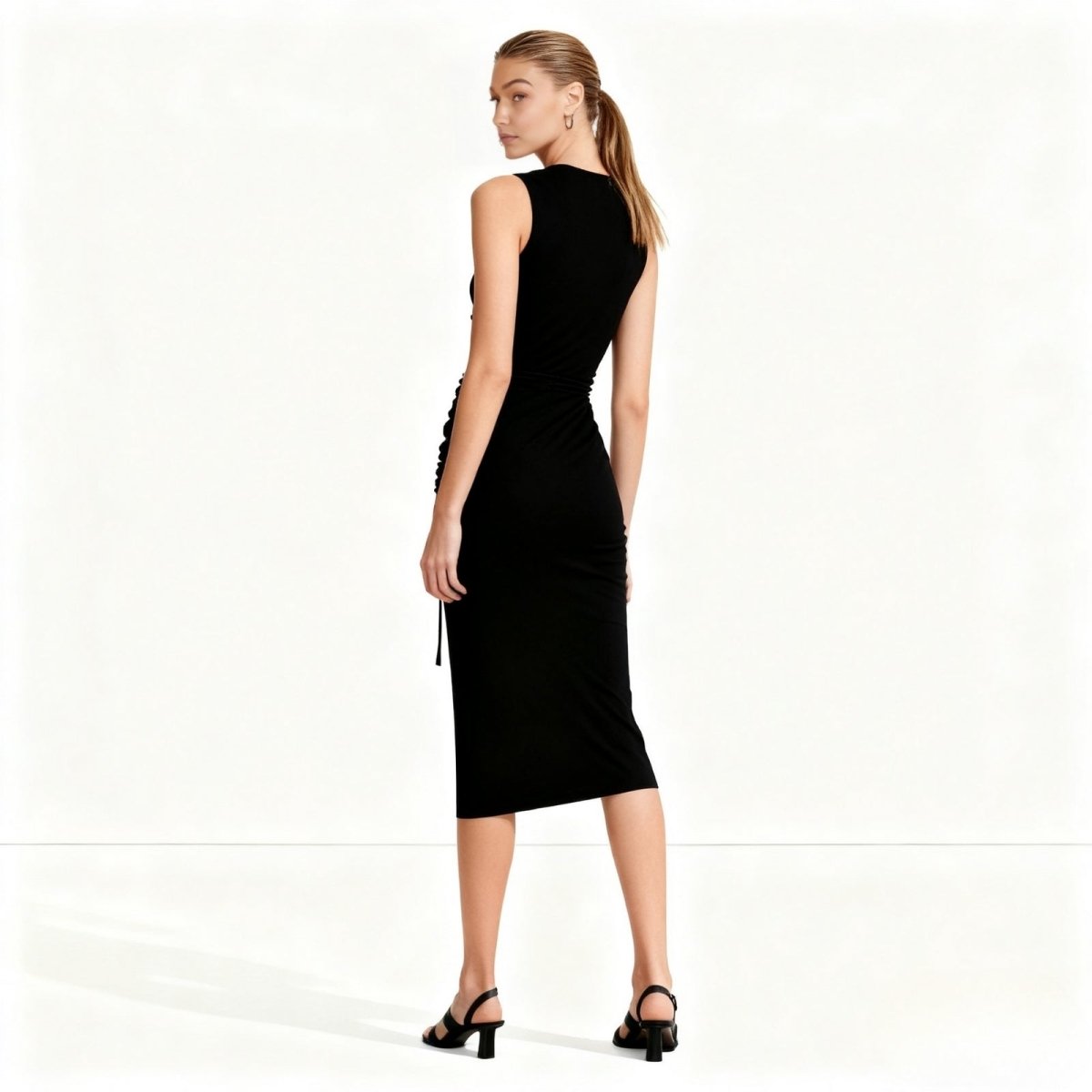 Gigi Hadid wearing a black Kouvr sleeveless dress on a white background
