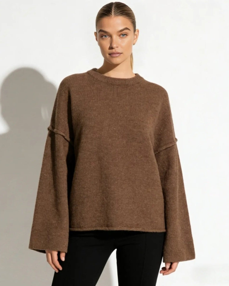 Model wearing the Krystal oversized bell sleeve sweater in a rich brown, showing the relaxed fit and crewneck from the front.