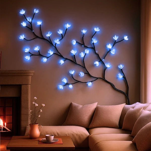 A detailed view of the lavender sculptural wall light, showing the texture of the hand-forged branches and the ethereal glow of the blue LED blossoms.