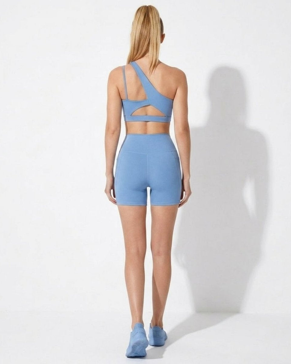 Back view of light blue athletic matching set showing stylish cut-out sports bra details and contouring high waisted biker shorts.