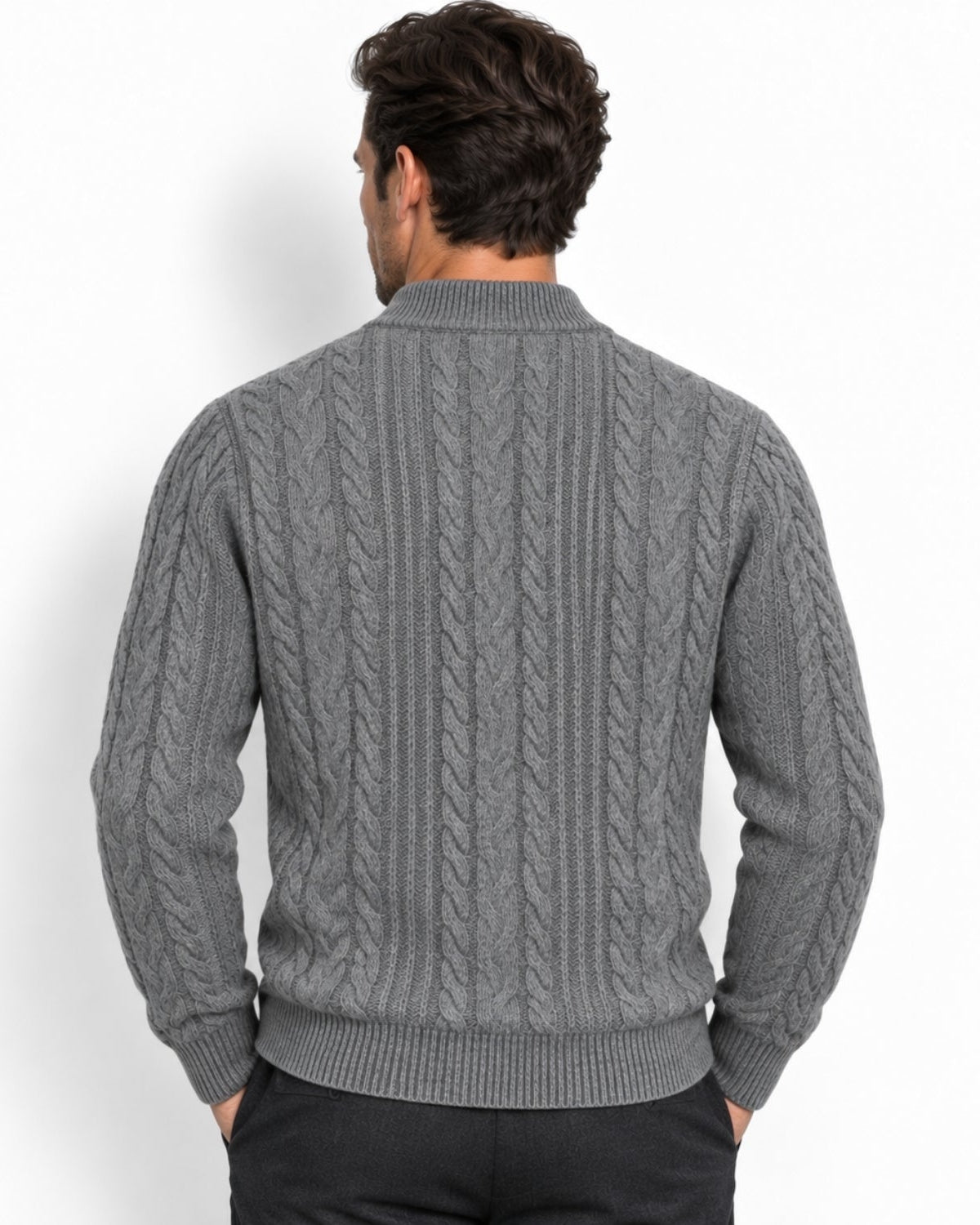 A man viewed from behind wearing a gray cable-knit sweater with a mock neck collar, paired with black trousers, against a plain white background.