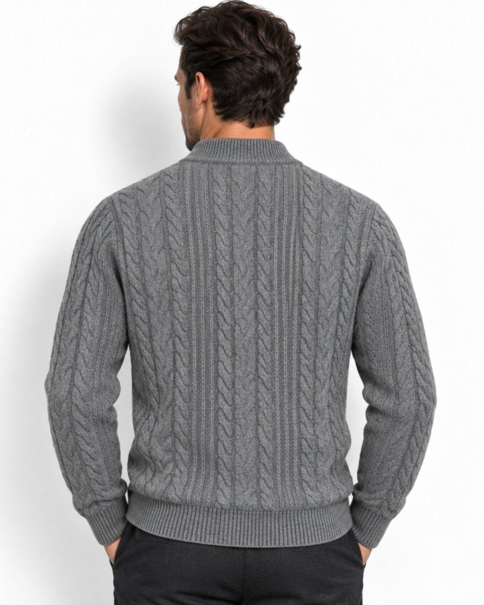 A man viewed from behind wearing a gray cable-knit sweater with a mock neck collar, paired with black trousers, against a plain white background.