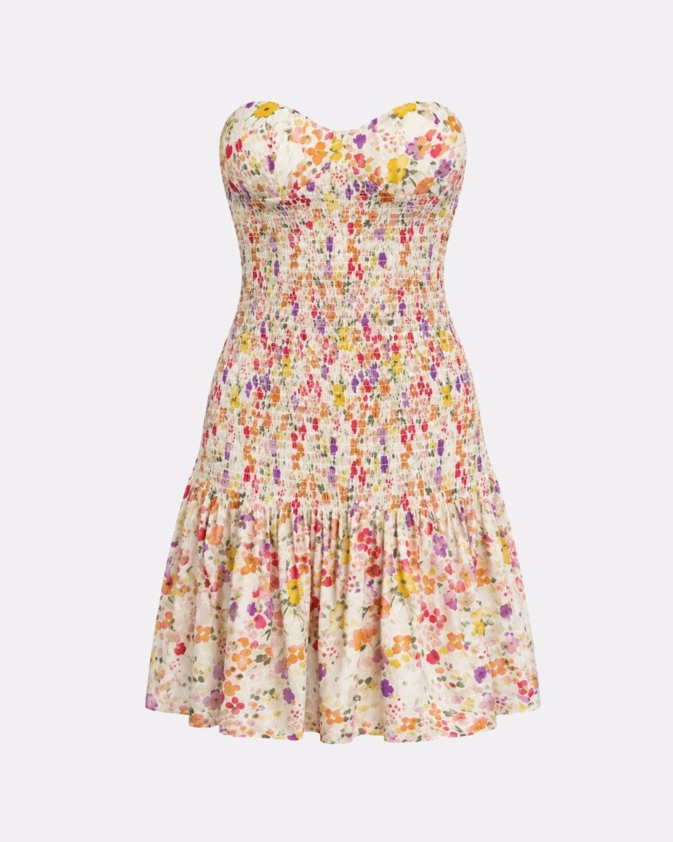 Flat lay studio product shot of the white floral strapless mini dress featuring vibrant yellow, pink, and purple blossom prints.