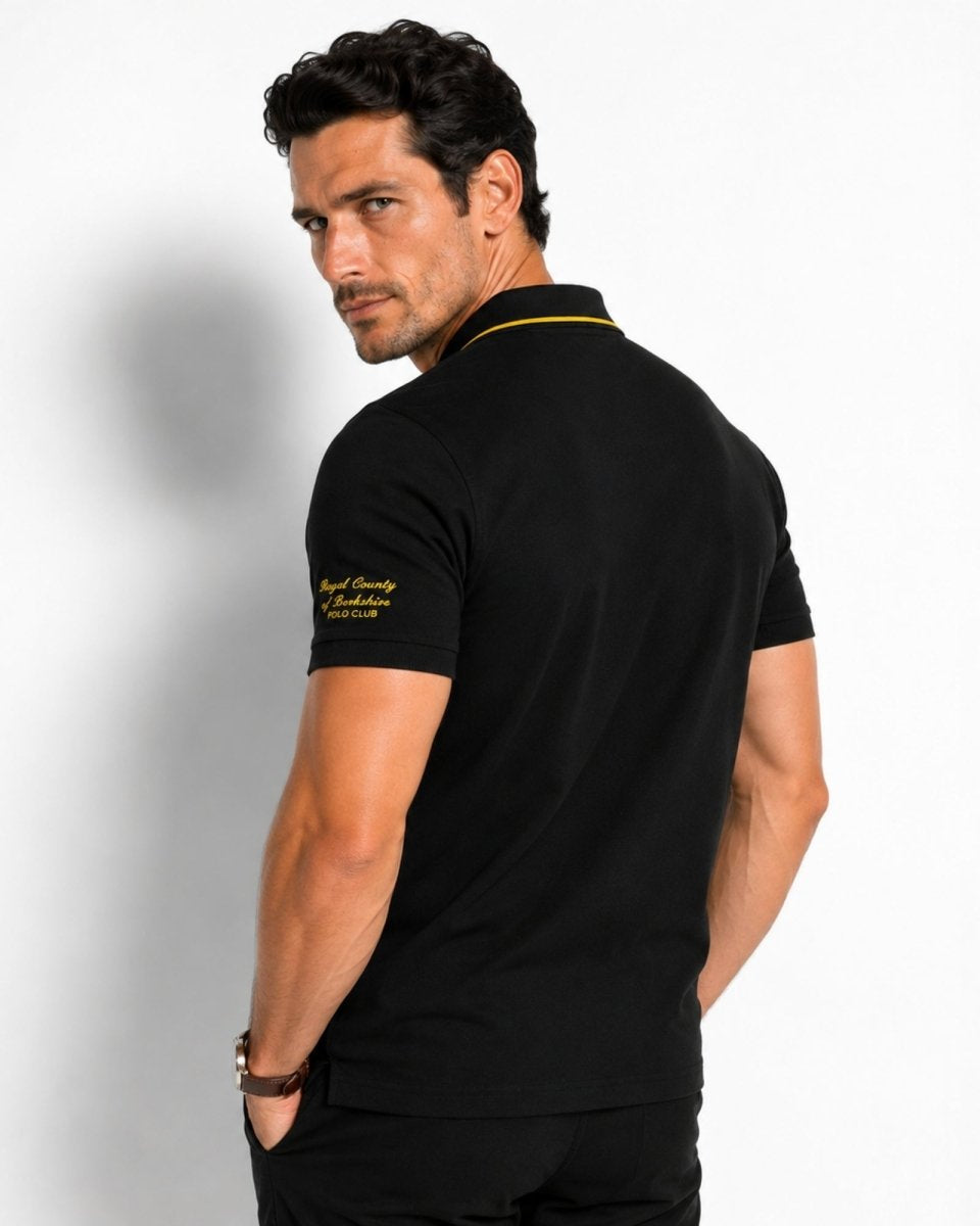 Man wearing a black polo shirt with yellow accents on a white background