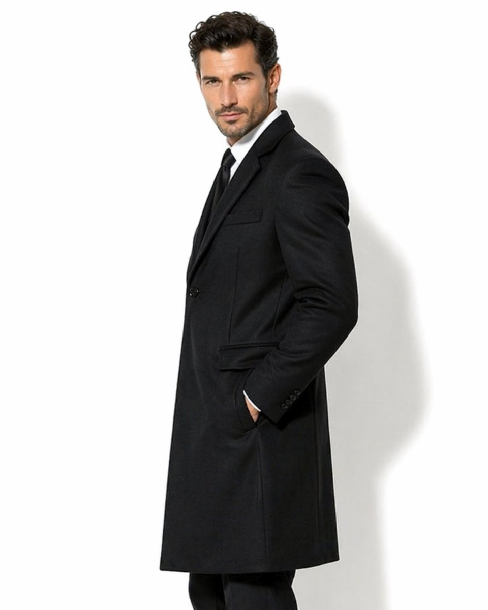 Side profile of men's classic black winter topcoat with hand comfortably resting in the front pocket, styled for business professional wear.