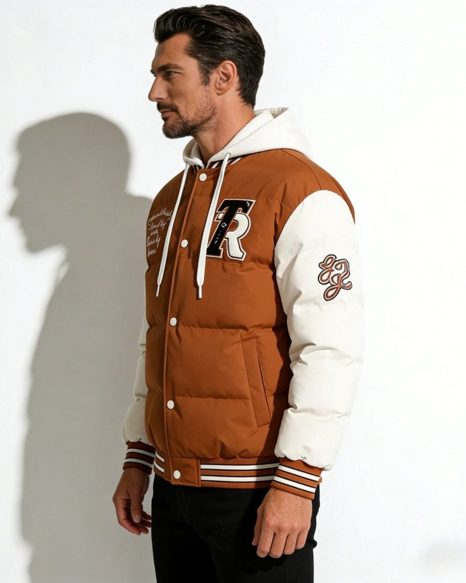 Side profile of a man wearing the hooded bomber jacket, highlighting the contrast padded sleeves and athletic sleeve patches.
