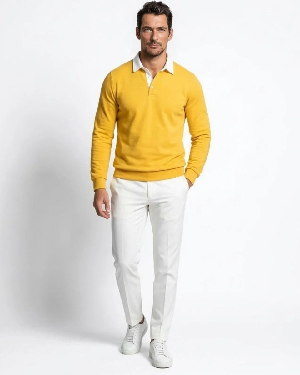 Male model wearing the yellow long sleeve knit polo sweater with a white collar, paired with white trousers.