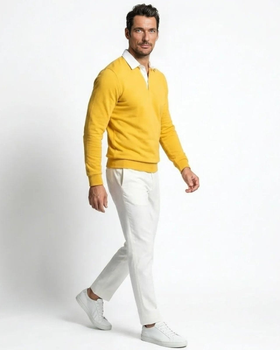 Side profile of a man walking in a yellow knit polo sweater, showing its regular fit and sleeve length.