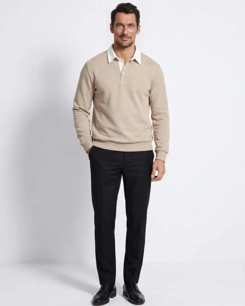 Man wearing the light beige long sleeve knitted polo sweater with black trousers, showing the classic fit.