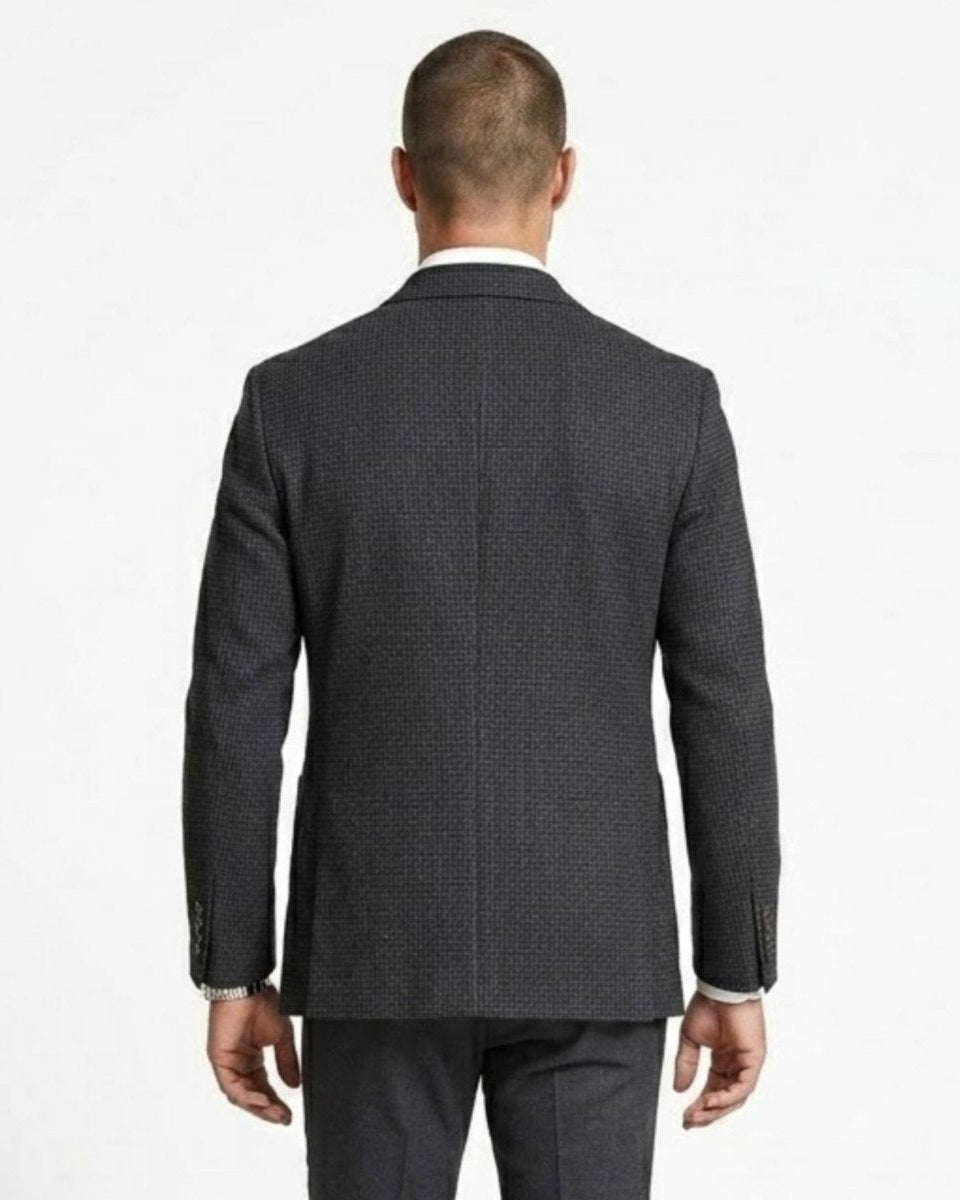 Close up back view of a man wearing a plaid slim fit sport coat showing double vent details.