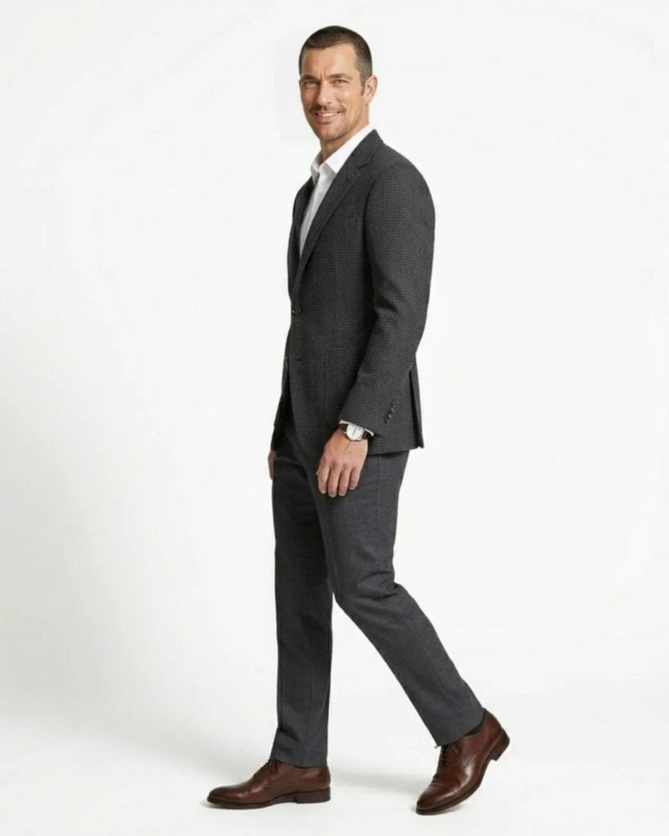 Side profile of a man walking confidently in a plaid two button patch pocket blazer.