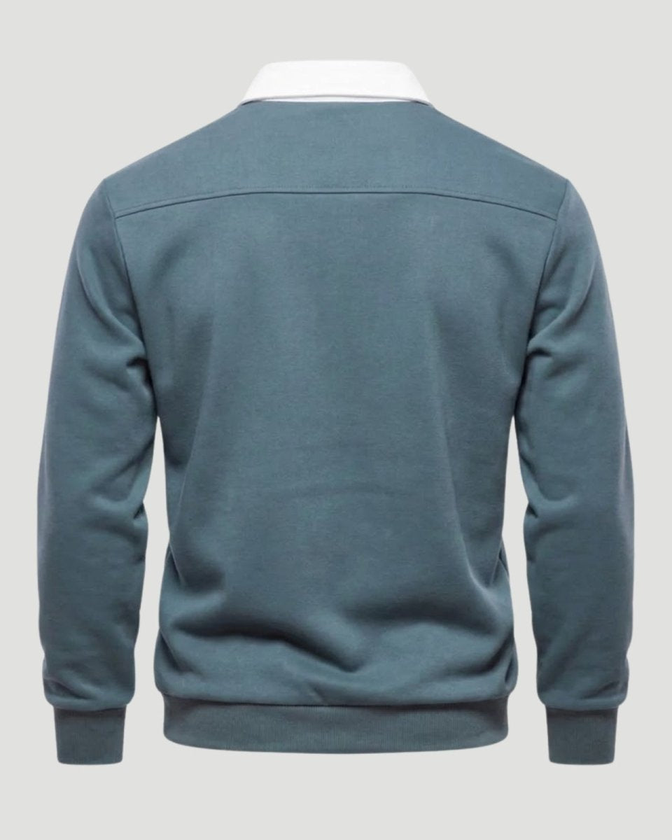 Flatlay studio shot of the back of a men's grey blue long-sleeve polo, showing the clean construction and shoulder yoke seam.