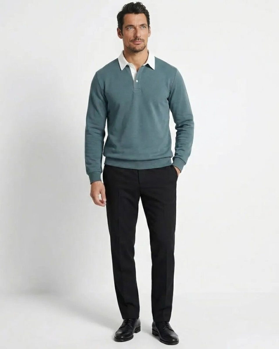 Man wearing grey blue long-sleeve knit polo sweatshirt with a white contrast collar, paired with black trousers.